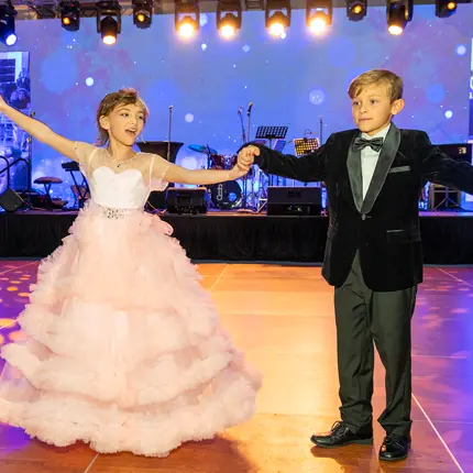 Osteosarcoma survivor, Olivia, dances with her friend, Aiden, at the annual Tiara Ball.